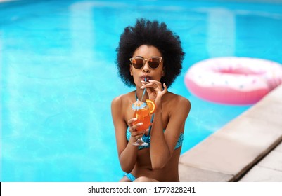 Sensual Black Girl In Bikini Drinking Yummy Fresh Cocktail Near Outdoor Swimming Pool