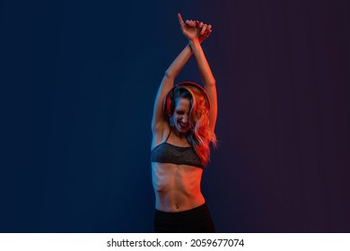 Sensual Blonde Woman Studio Portrait With Headphones. Colored Gel Photography.