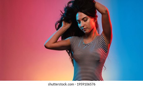 Sensual Brunette Woman Studio Portrait Wearing Black And White Stripes Body. Colored Gel Photography.