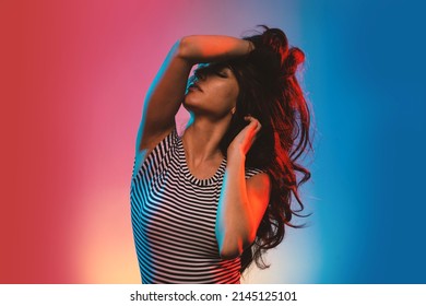 Sensual Brunette Woman Studio Portrait Wearing Black And White Stripes Body. Colored Gel Photography.