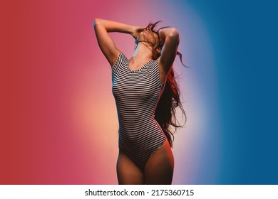 Sensual Brunette Woman Studio Portrait Wearing Black And White Stripes Body. Colored Gel Photography.