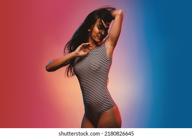 Sensual Brunette Woman Studio Portrait Wearing Black And White Stripes Body. Colored Gel Photography.