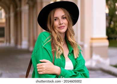 Sensual Nahaufnahme von stylischen blonden Frau mit lockigen Haaren natürlichen Make-up und hübschen Gesicht, mit schwarzem Hut auf der Kamera, posieren auf der Straße, Sommerzeit.
