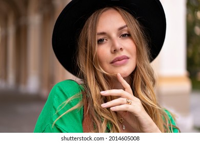 Sensual Nahaufnahme von stylischen blonden Frau mit lockigen Haaren natürlichen Make-up und hübschen Gesicht, mit schwarzem Hut auf der Kamera, posieren auf der Straße, Sommerzeit.