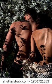 Sensual couple in cherry bloom. Naked woman man in love in blossoming spring tree flower. Romance, relationship, nature, environment concept