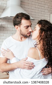 sensual couple embracing with closed eyes in kitchen - Shutterstock ID 1387408328