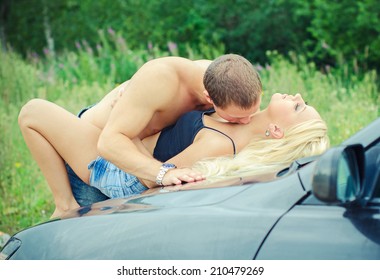 Sensual couple making love on the car's hood.