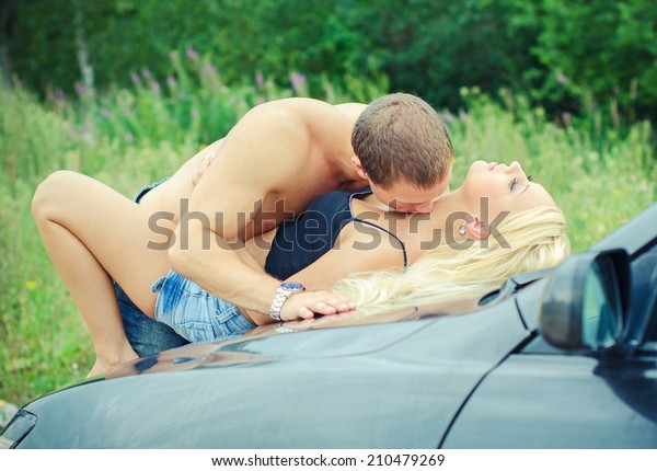 Sensual couple\
making love on the car\'s\
hood.