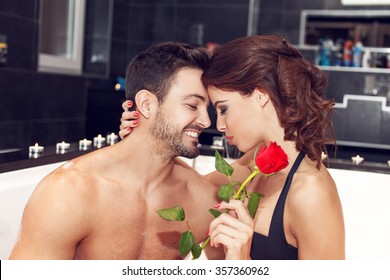 Sensual couple with rose in jacuzzi, honeymoon