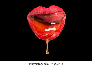 Sensual female red lips licking honey with tongue closeup on black background