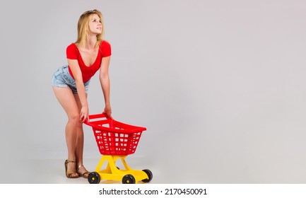 Sensual Girl With Empty Shopping Cart. Buying Spree. Woman Shopper In Supermarket. Sale. Discount.