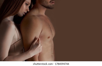 sensual girl has tender feelings for a man, hugs him. shirtless man with strong musles and redhead woman in bra have harmonious relationships