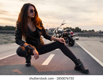 Sensual motorcycle girl posing on the track