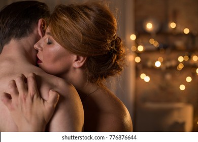 Sensual Naked Lovers Are Cuddling With Passion. Female Eyes Are Closed With Pleasure. Couple Is Standing At Bedroom In Romantic Atmosphere. Copy Space