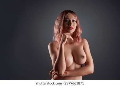 Sensual naked woman touching chin and looking at camera