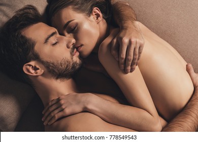 sensual naked young couple hugging and sleeping together in bed 