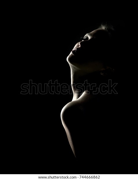 Sensual\
portrait of woman in shadow on dark\
background