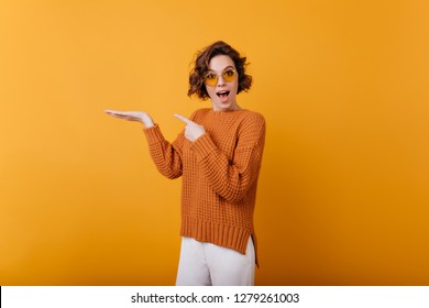 Sensual pretty girl wears round yellow glasses posing in studio. Indoor photo of graceful positive woman expressing happiness. - Shutterstock ID 1279261003