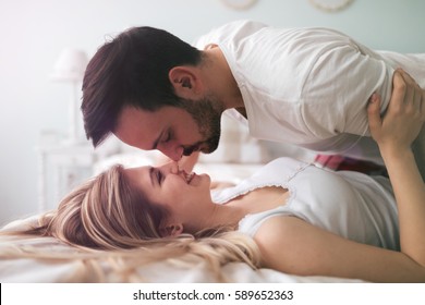 Sensual romantic foreplay by couple in love in bed