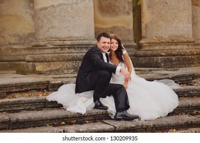 Sensual Wedding Couple, Groom And Bride Sits On The Steps Of An Old Church.