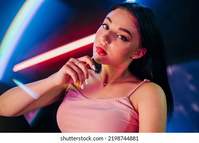 Sensual Woman Red Lips With A Lollipop. Candy Bar On Neon Lights Concept. Beautiful Woman Portrait