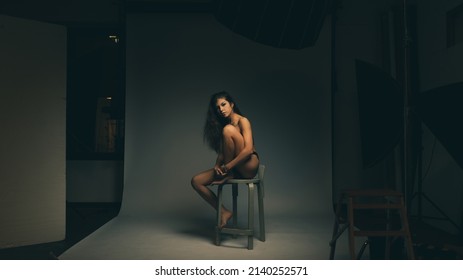 Sensual Woman Wearing Black Lingerie Portrait Sit On Stool. Studio Portrait. Filtered Image.