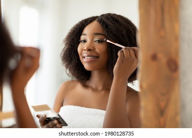 Sensual Young Black Woman Applying Eye Shadow With Applicator Near Mirror At Home. Beautiful African American Lady Using Decorative Makeup, Using Organic Cosmetic Product