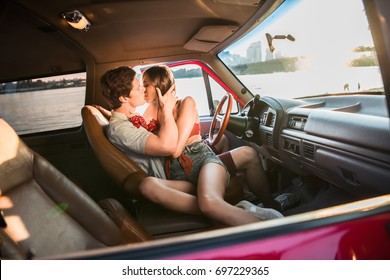 sensual young couple kissing while sitting in car