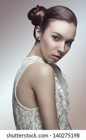 Sensual Young Girl With Brown Hair Tied In Lateral Chignon Hair-style Looking In Camera And Wearing Sexy Lace Shirt