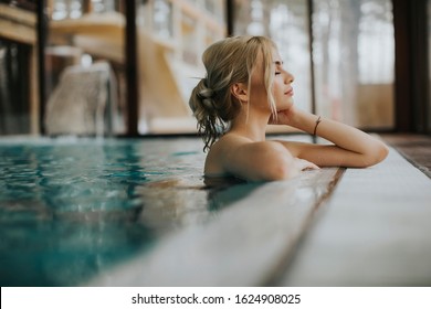 Sensual young woman relaxing in spa swimming pool
