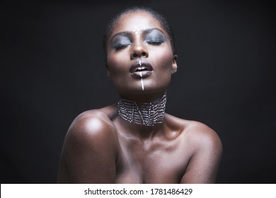 Sensuous young woman with painted face over black background