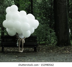 Sentimentality. Nostalgia. Lonely Woman with Air Balloons sitting on Bench in the Park