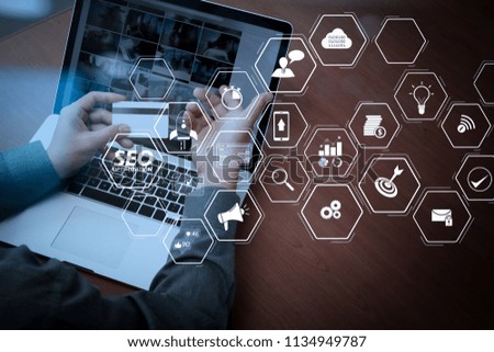 Seo Optimization for website with mobile website and Landing page virtual diagram.hands using laptop and holding credit card with social media diagram as Online shopping concept