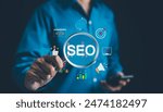 SEO Search Engine Optimization Concept. Businessman hold magnifying glass focuses highlighting SEO, surrounded by various digital marketing icons, representing search engine optimization strategies.