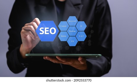 SEO Search Engine Optimization concept, Human hand pointing promoting ranking traffic on website, optimizing your website to rank in search engines or SEO on virtual screen over tablet.
