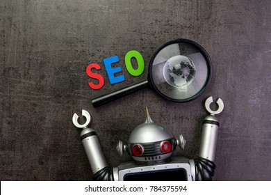 SEO Search engine optimization concept with alphabet abbreviation SEO and globe on magnifying glass and vintage robot.