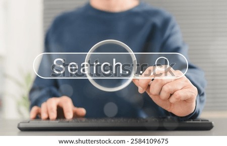 SEO search engine optimization concept. Person uses keyboard while holding magnifying glass with search bar labeled "Search", online search engine optimization, and digital marketing strategies.