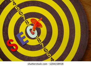 SEO Search Engine Optimization multi color alphabets ranking concept on dartsboard background with red arrow hit center of target, SEO is one of online marketing business strategy to promote website.
