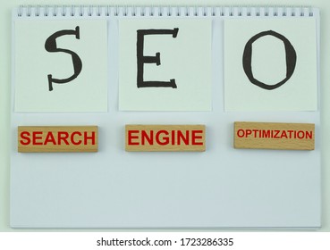SEO, search engine optimization ranking concept, inscription with black SEO marker on white paper with wooden blocks, idea of promoting traffic to a site.