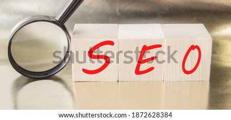 SEO search engine optimization text wooden cubes and magnifying glass on a Golden background. Idea, vision, strategy, analysis, Keyword and content concept.