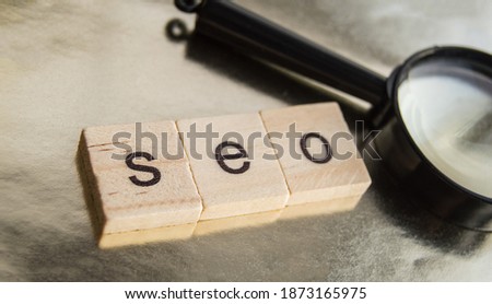 SEO search engine optimization text wooden cubes and magnifying glass on a Golden background. Idea, vision, strategy, analysis, Keyword and content concept.