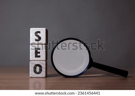 SEO Search Engine Optimization wooden block text and magnifying glass on table