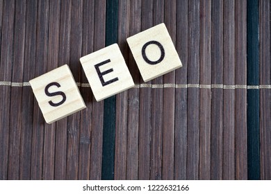 SEO, Search Engine Optimization word collected of wooden elements with the letters and also magnifying glass.