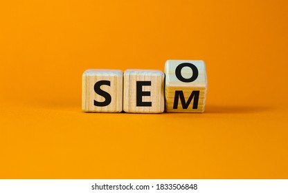 SEO versus SEM. Turned a cube and changed the expression 'SEO' to 'SEM' or vice versa. Concept for Search Engine Optimization and Search Engine Matketing. Beautiful orange background, copy space.