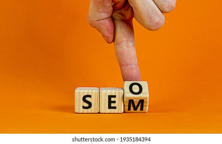 SEO vs SEM symbol. Businessman turns a cube and changes words SEO, Search Engine Optimization to SEM, Search Engine Matketing. Business, SEO vs SEM Concept. Beautiful orange background, copy space.