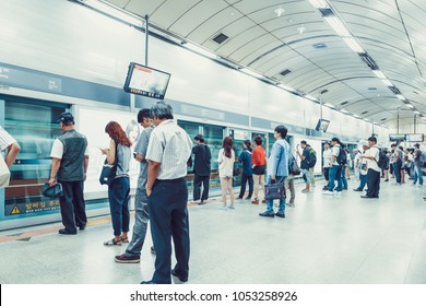 SEOUL, KOREA - AUGUST 12, 2015: Different people standing in the line on a subway platform and patiently waiting for their train to come - Seoul, South Korea