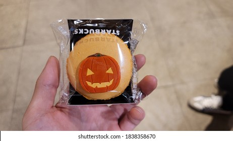 Seoul, Korea - Oct 18 2020: Image Of Halloween Treat From Starbucks Korea. Pumpkin Decoration Chocolate On Orange Macaron.