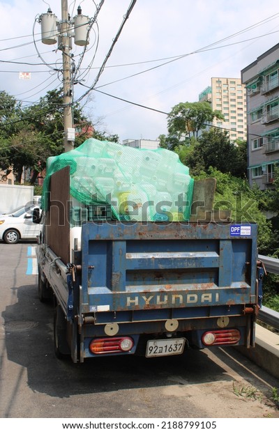 Seoul,\
Korea-August 4, 2022: Recycling truck parked beside a creek\
bisecting Jeongneung Market, in Jeongneung,\
Seoul