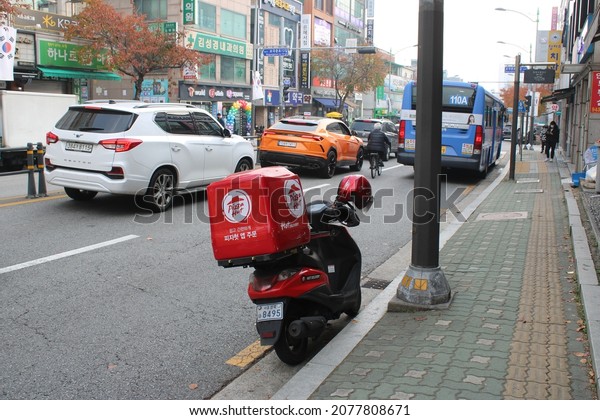 Seoul,\
Korea-November 19, 2021: Pizza Hut delivery motorbike parked\
alongside busy street, in Jeongneung,\
Seoul