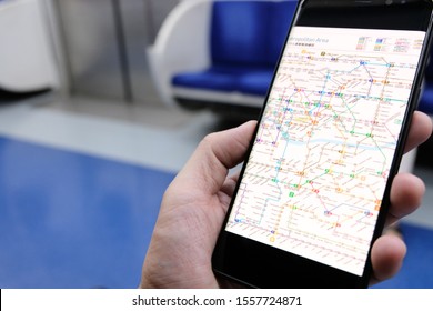 Seoul, South Korea 12 Nov 2019. Men hand holding smart phone device check metro train system map for traveling in the city by public transportation. Easy quick choice for tourist to explore the city